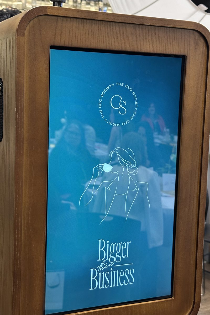 The booth's rear screen showing the conference's design, 'Bigger than Business'